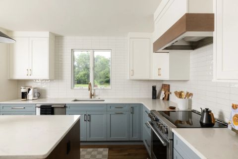Taylors transitional kitchen with two-tone shaker cabinetry, white uppers, light blue-grey lowers, gold hardware, white quartz countertops, and subway tile backsplash by Tekton Builds.